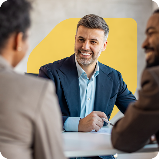 Homme professionnel en costume assis au bureau et souriant à des clients
